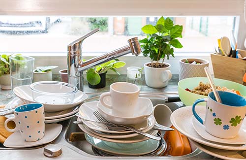 dishes over filling the sink in a hoarded home