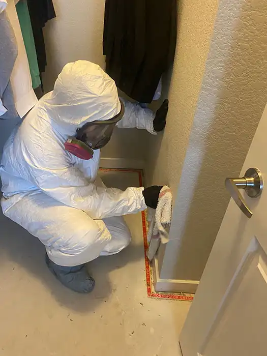 biohazard technician cleaning body fluids off a wall
